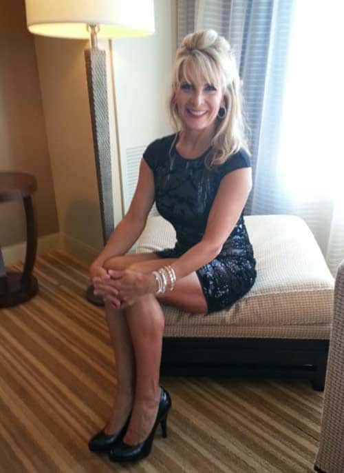 Femme mature blonde dans une chambre d'hotel en mode scort